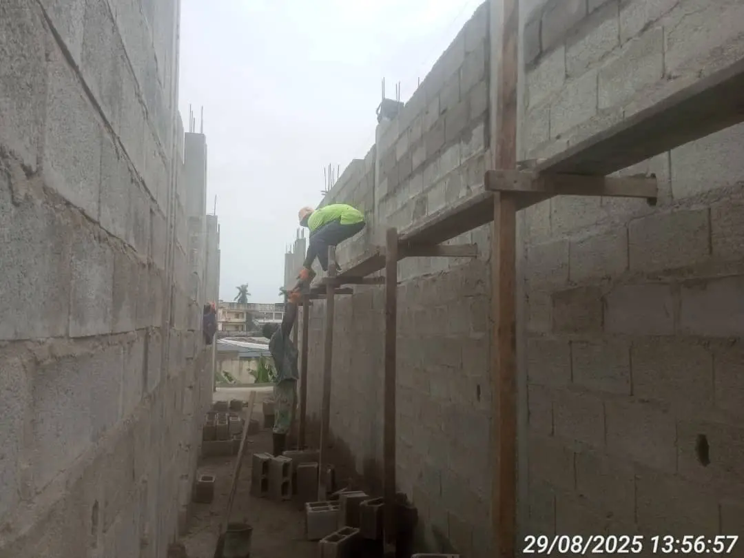 Maçons au travail sur les murs du premier niveau