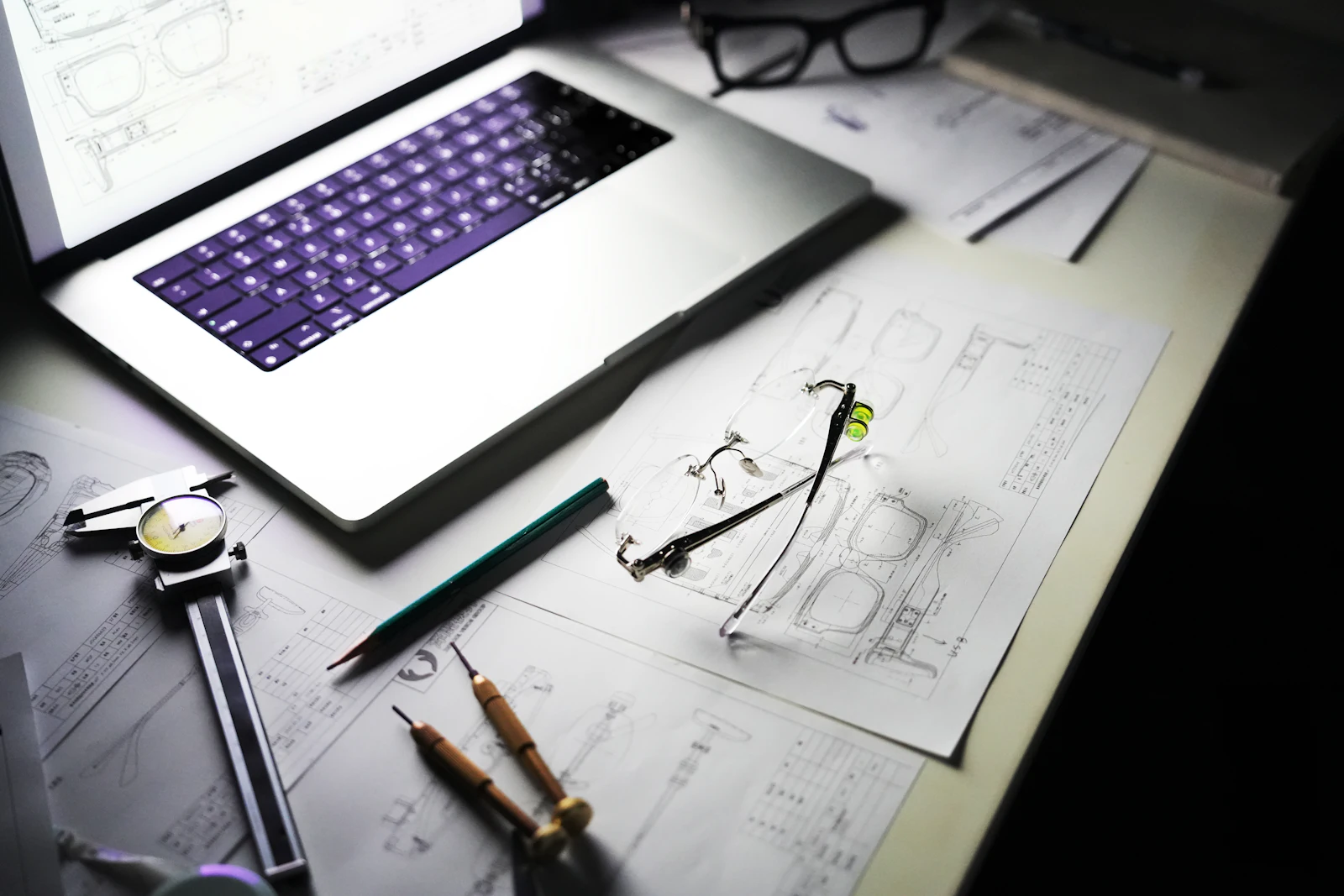 Plans techniques et ordinateur portable sur un bureau d’études